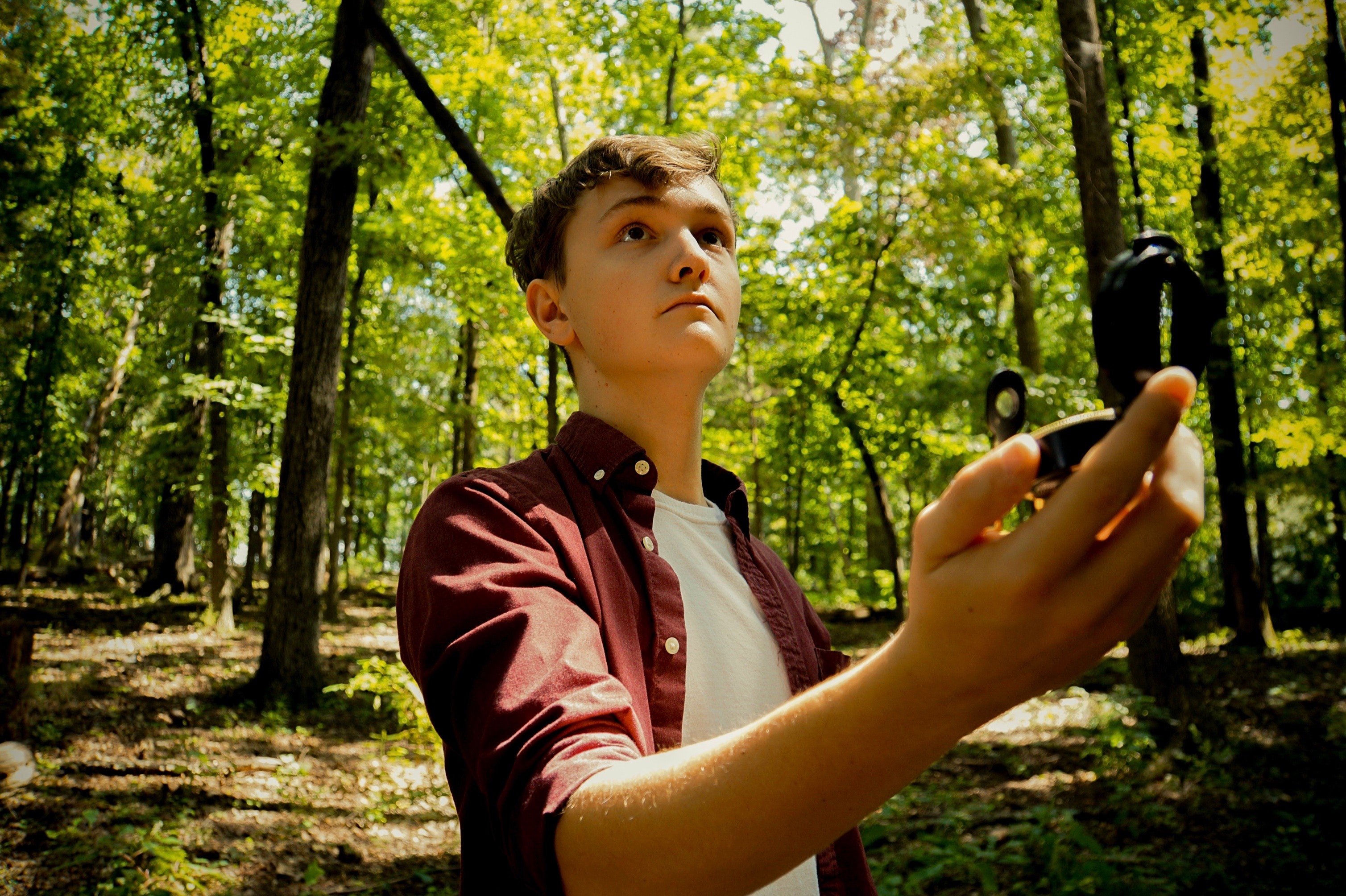 Boy with compass in the woods